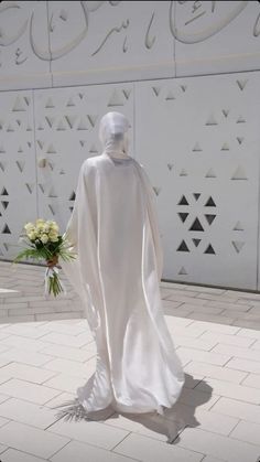 a white statue is standing in front of a wall