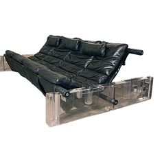 a black leather couch sitting on top of a plastic box