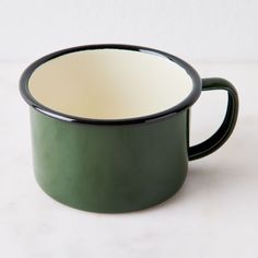 a green and white cup sitting on top of a table