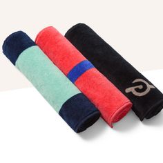 three towels folded on top of each other with the letter g in gold, green, blue and red