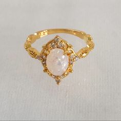 an opal and diamond ring on a white surface