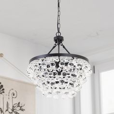 a chandelier hanging from the ceiling in a room with white walls and windows