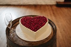 a heart shaped cake on top of a wooden barrel