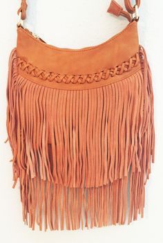 This casual crossover bag is your next best friend! With a top zip closure and back zip pocket, this small bag can easily fit all your everyday items in it. The front features a faux leather cross stitch detail with a fun boho suede fringe that hangs about 10" long. The shoulder bag has a 45" strap and interior zip pocket. So grab a girlfriend and go exploring in the 'City of Austin' with this must have accessory to go with your favorite denim. Available in camel. Vegan leather and suede. 9" x 8 Crossover Bags, Suede Fringe, Everyday Items, Small Bag, Boho Shorts, Camel, Austin, Vegan Leather, Faux Leather