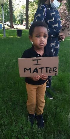 a little boy holding a sign that says i matter