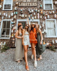 three women standing in front of a brick building