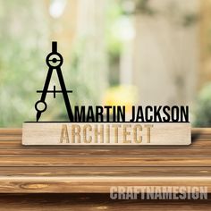 a wooden table with a sign that says martin jackson's architecture and a compass on it