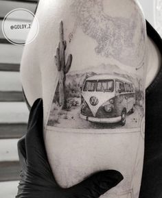 a black and white photo of a vw bus on the back of a woman's shoulder