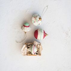 three ornaments are sitting on the wall next to each other, one is red and white