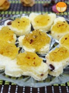 small desserts are arranged on a glass plate with silverware and other food items in the background