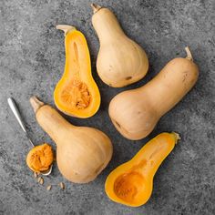 butternuts and squash on a gray surface with a knife next to one that has been cut in half