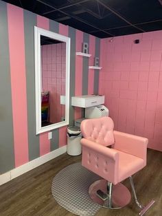 a pink chair sitting in front of a mirror