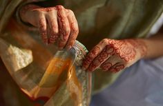 a woman with henna on her hands holding something