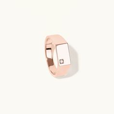 a rose gold ring with a square diamond on the center and an invisible band around it, against a white background