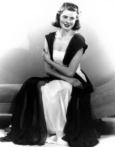 black and white photograph of a woman sitting on a couch with her arms folded over her chest