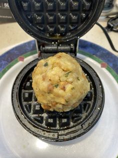 a close up of a waffle maker on a plate with food in the middle