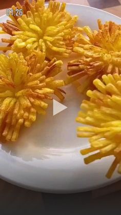 three yellow flowers are on a white plate