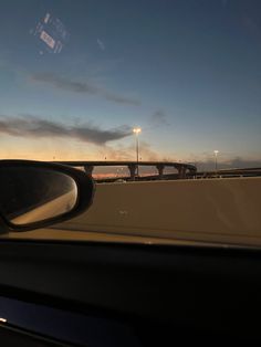 the sun is setting on an overpass and cars are driving