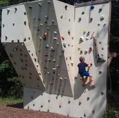 a young boy climbing up the side of a rock wall