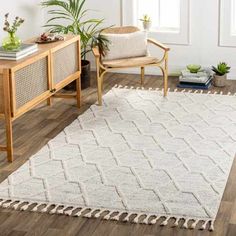 a living room area with a rug, chair and plant on the side walk way