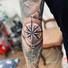 a man's arm with a compass tattoo on it