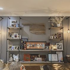 a living room filled with lots of furniture and shelves covered in pictures on top of them