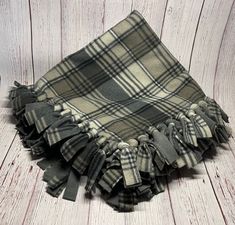 a plaid blanket laying on top of a wooden floor