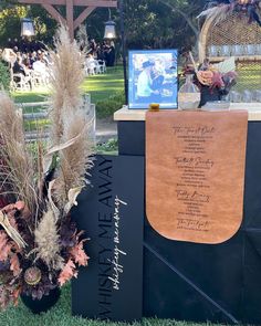 an outdoor ceremony setup with flowers, candles and pictures on the side of the table