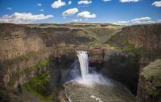 a large waterfall in the middle of a canyon