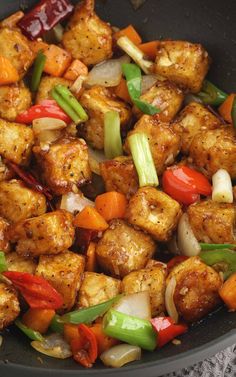 a pan filled with tofu and vegetables on top of a table