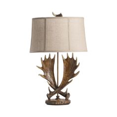 an antler lamp with a beige shade on it's side and a white background