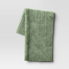 a green towel folded on top of a white table