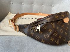 Overview Louis Vuitton Bum Bag in Canvas Monogram with gold hardware. Fashioned in classic Monogram canvas and signed with a “Louis Vuitton Paris” leather patch, this uber-functional bumbag transforms sportwear into the very definition of casual chic. Wear it as a belt bag, cross-body or over the shoulder for a jauntier look. Now discontinued this item is highly sought after. Features Monogram coated canvas Gold hardware Smooth cowhide leather trim Cotton canvas lining 1 main compartment with double zip closure 1 adjustable belt and top handle 1 D ring 1 natural cowhide leather patch Condition Exterior: Excellent condition with only light signs of wear. Minor marks to leather belt / strap. Slight wrinkling to strap. Interior: Excellent condition with minor marks. Hardware: Excellent condit Louis Vuitton Bum Bag, Louis Vuitton Bumbag, Louis Vuitton Paris, Classic Monogram, Louis Vuitton Shoes, Dior Shoes, Bum Bag, Vuitton Bag, Adjustable Belt