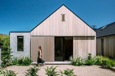 a person standing in front of a building with wooden siding on the walls and windows