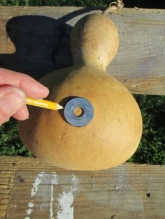 a person holding a pencil in their left hand and pointing at a piece of pottery