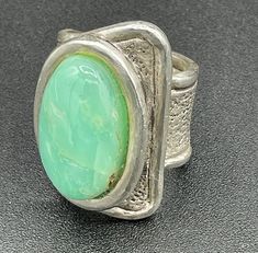 Introducing this most unusual and elegant Sterling Silver Ring with large Chrysoprase cabochon. Crafted with an eye for beautiful stones, this ring features the soothing colors of moss green and warm brown highlighted by a textured but simple sterling silver design.  The elegance and simplicity of this large ring is show stopping. The size is 10.5 so perfect for an index or middle finger. Whether you're dressing up for a special occasion or adding a touch of glamour to your everyday look, this r Green Board, Green Rings, Beautiful Stones, Brown Highlights, Silver Design, Large Ring, Soothing Colors, Warm Brown, Moss Green