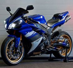 a blue motorcycle parked in front of a garage door