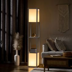 This 2-light floor lamp features a boxy, column silhouette that illuminates any room. Reminiscent of a clean-lined modern bookcase, it has a sleek frame made from engineered wood and plastic. Rectangular white fabric shades at the top and the bottom temper the light from two dimmable 40W max bulbs (sold separately). Our favorite perk? Two shelves in the center are just the right spot to hold books, decor, and more. At 61.5" tall and 10.25" square, this lamp is ideal for space-conscious areas aro Lamp With Shelves, Standing Lamp Living Room, Modern Column, Shelf Floor Lamp, Shelf Lamp, Lamp Making, Corner Floor Lamp, Column Floor Lamp, Bottom Light