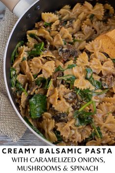 creamy pasta with caramelized onions, mushrooms and spinach in a skillet