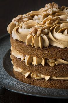 a cake with walnuts and frosting on a plate