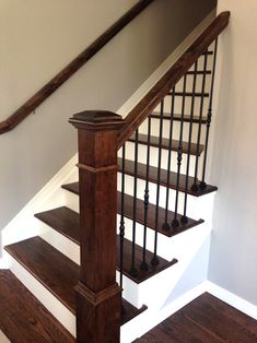 an empty staircase with wooden handrails and white walls