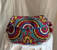 Medium gusseted Silk Petit Point Handbag created and hand made in Uzbekistan. Lined with silk ikat fabric, hand woven straps with tassels and a magnetic closure. Each handbag is hand drawn on to cotton canvas, inspired by original designs from Uzbekistan textile history. Measures  7" high x 9.5" width x 2.5" gusset, 8" opening approx. 53" strap x 3/4" width.  Can fit largest sizes of iPhone and Android. 100% silk on cotton canvas. Your purchase preserves and encourages Folk Art Traditions in Uzbekistan, enabling women, families and communities to preserve their traditions and contributes to the health and well being of the communities at large. Your purchases helps a long chain of women working hard to preserve our dignity and integrity to live in a world that recognizes creativity in it's Textile History, Silk Ikat, Ikat Fabric, Embroidered Silk, Magnetic Closure, Cross Body Handbags, Purses And Handbags, Hand Woven, Folk Art