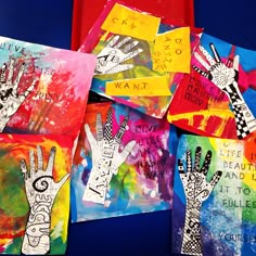 several handprints are displayed on colorful paper