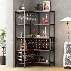 a shelf filled with bottles and glasses on top of a wooden floor next to a lamp