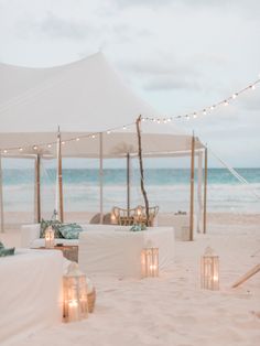 an outdoor seating area with candles on the beach