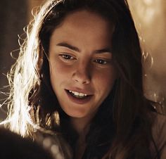 a woman with long hair smiling at the camera