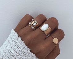 a woman's hand with three different rings on her fingers and one is wearing a ring