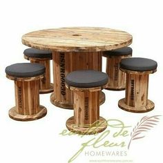 a round wooden table with four stools around it