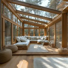 a living room filled with lots of furniture and large glass windows on top of it