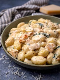 a bowl filled with macaroni and cheese on top of a blue table cloth